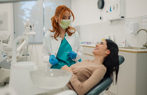 Dentist talking to smiling patient in treatment chair