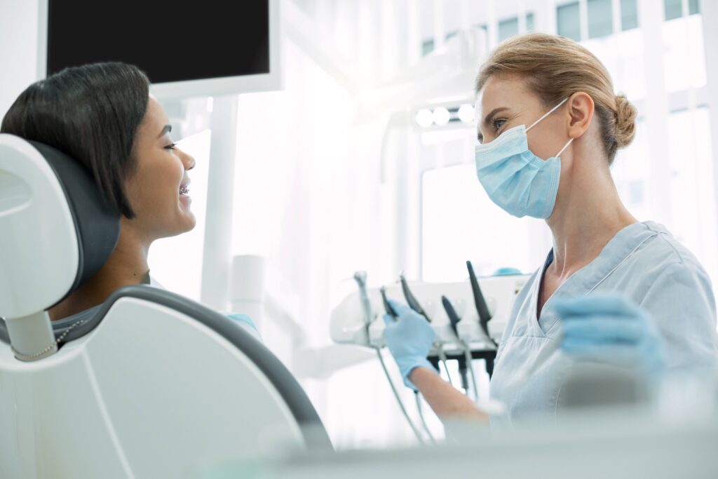 Patient and dentist smiling at each other during exam